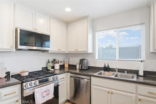 a kitchen with stainless steel appliances granite countertop a sink a stove and a microwave