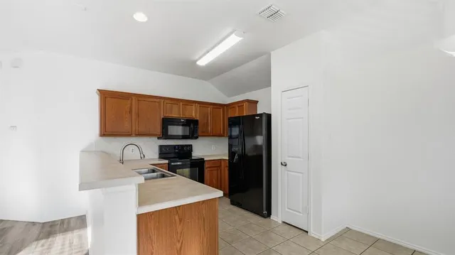 a kitchen with stainless steel appliances granite countertop a refrigerator and a sink