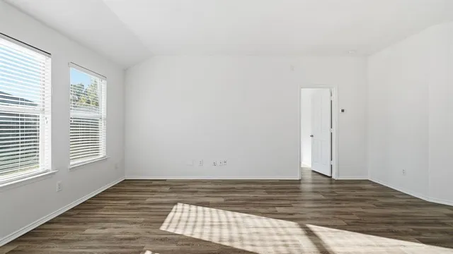 a view of room with window and wooden floor