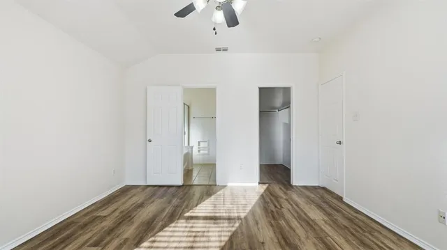 a bedroom with a bed and a chandelier fan