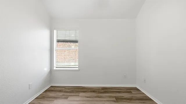 a view of a small space with wooden floor and a window