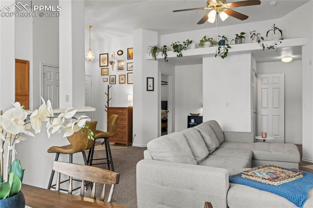3976 Riviera Grove, Unit 203 Colorado Springs, CO 80922 - Photo 7 of 45 a living room with furniture and a chandelier