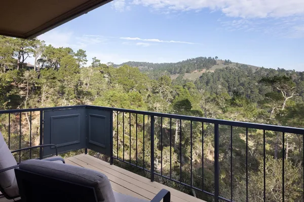 a balcony with wooden floor and outdoor seating