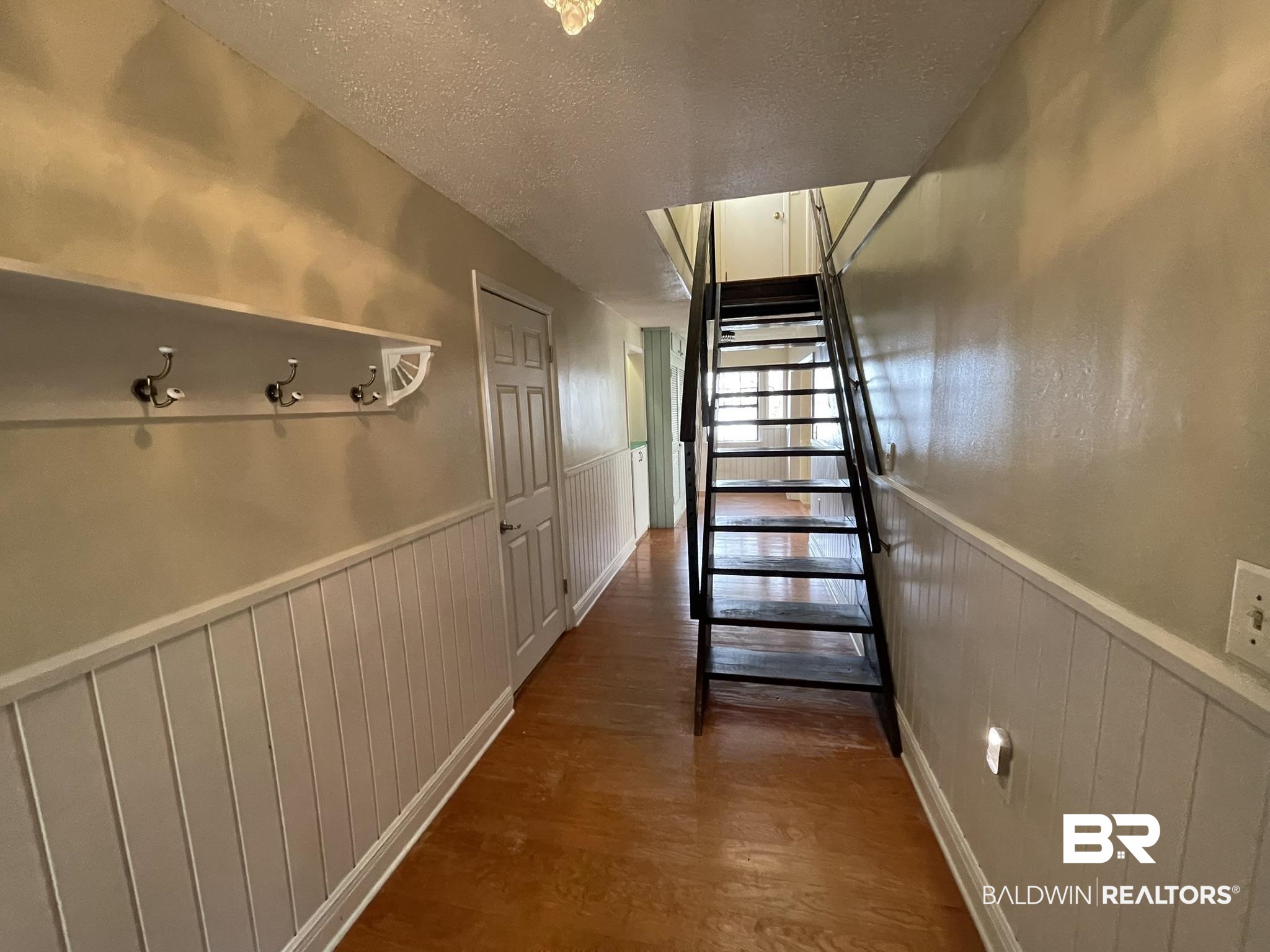 6621 Purvis Road Daphne, AL 36527 - Photo 32 of 59 Staircase with a textured ceiling, wood finished floors, and a wainscoted wall