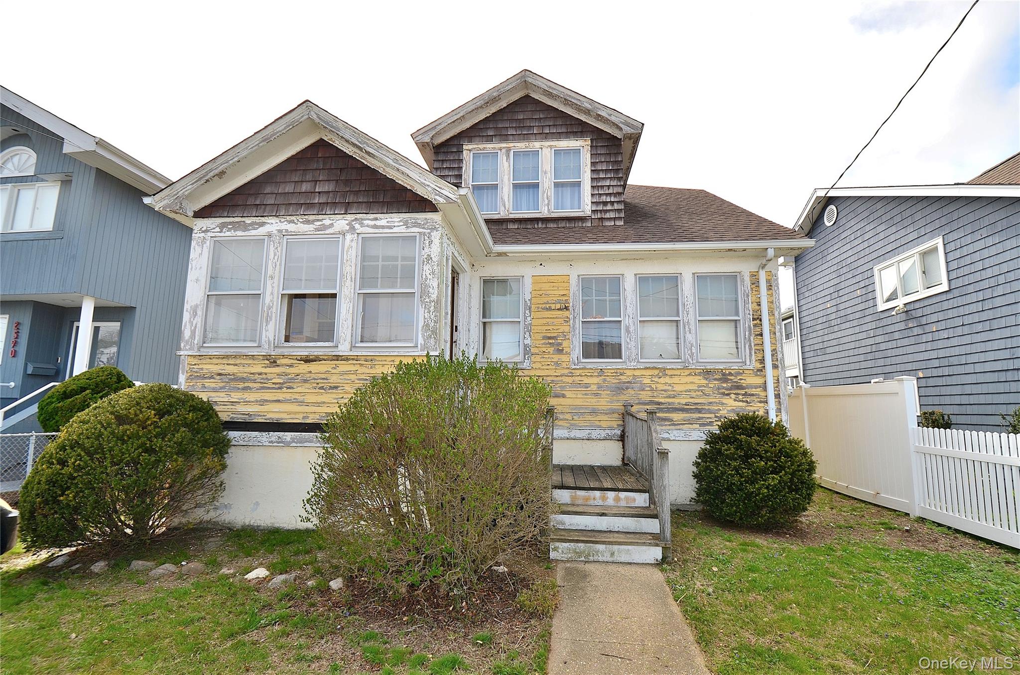 2586 Riverside Drive Wantagh, NY 11793 - Photo 3 of 9 The property features a front yard with a wooden front porch with stairs