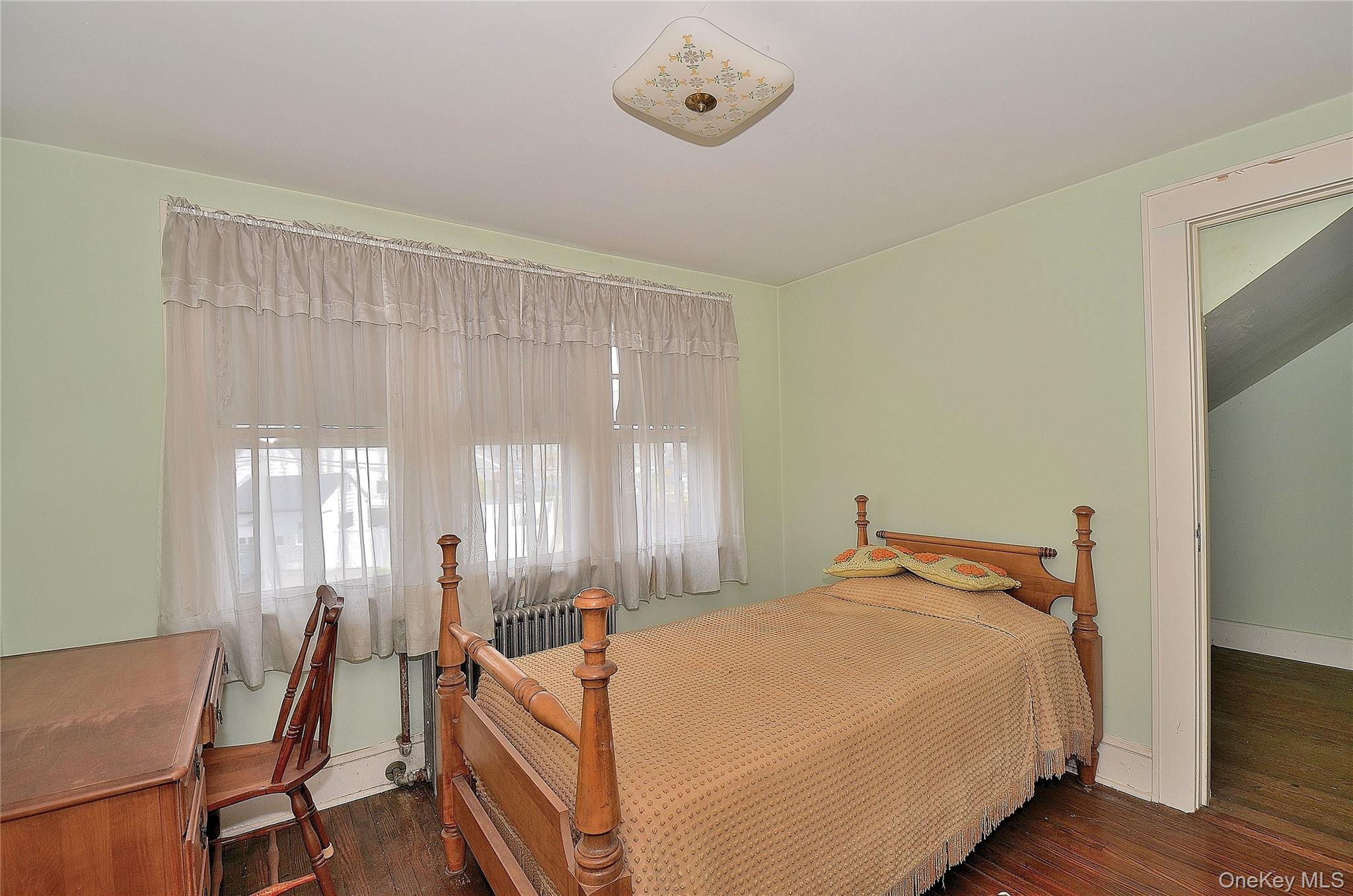 2586 Riverside Drive Wantagh, NY 11793 - Photo 5 of 9 This room features hardwood floors, light green walls, a window with sheer curtains, and a ceiling-mounted light fixture