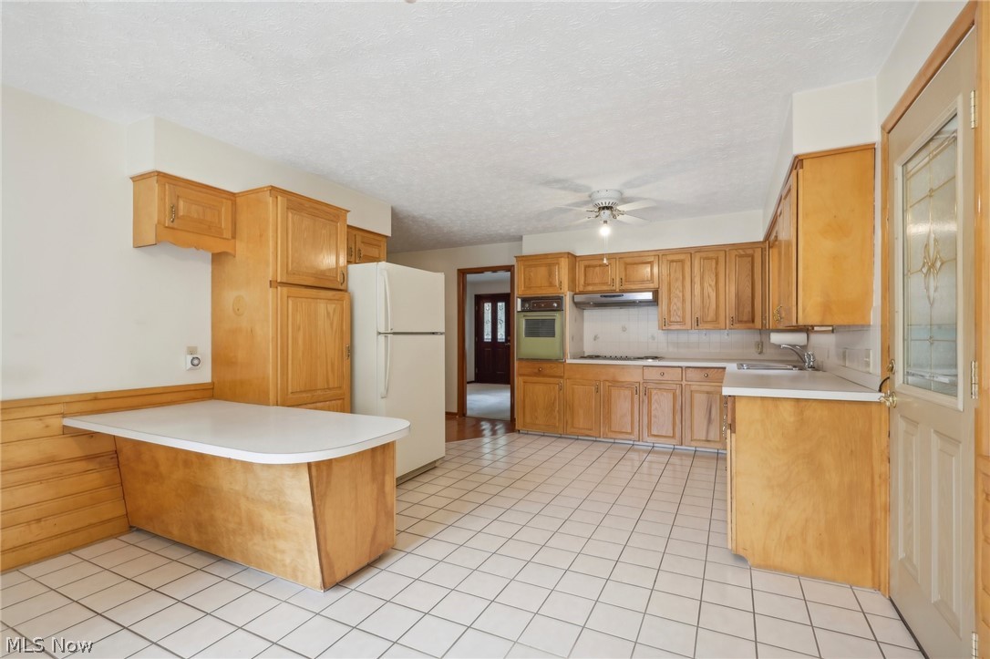3873 Baumberger Road Stow, OH 44224 - Photo 10 of 50 Kitchen with white fridge, light tile flooring, oven, cooktop, and sink