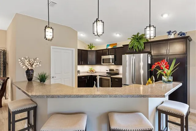 a kitchen with stainless steel appliances a sink a refrigerator a stove a washer and dryer