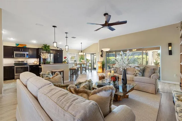a living room with furniture or wooden floor and a ceiling fan
