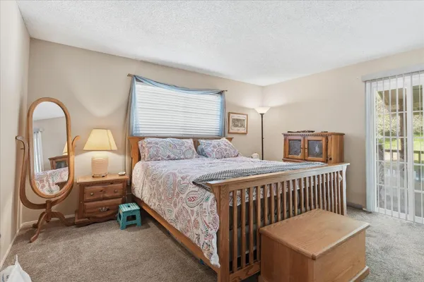 a bedroom with a bed a mirror and windows