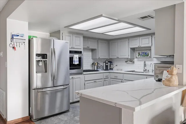 a kitchen with white cabinets and sink