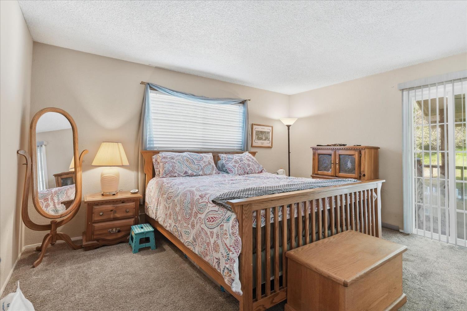 40182 Alerna Way Oakhurst, CA 93644 - Photo 16 of 49 a bedroom with a bed a mirror and windows