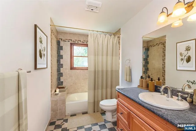 a bathroom with a granite countertop sink toilet a mirror and shower