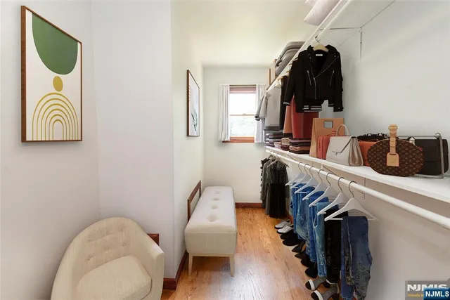 a view of walk in closet with clothes and shoes
