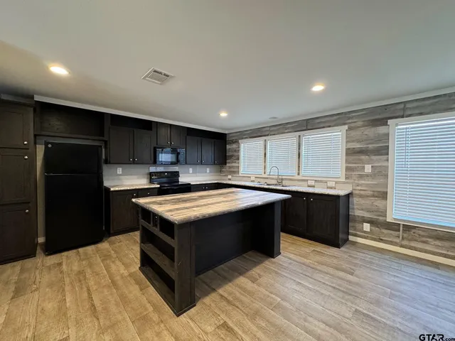 a kitchen with stainless steel appliances granite countertop a stove a refrigerator and a sink