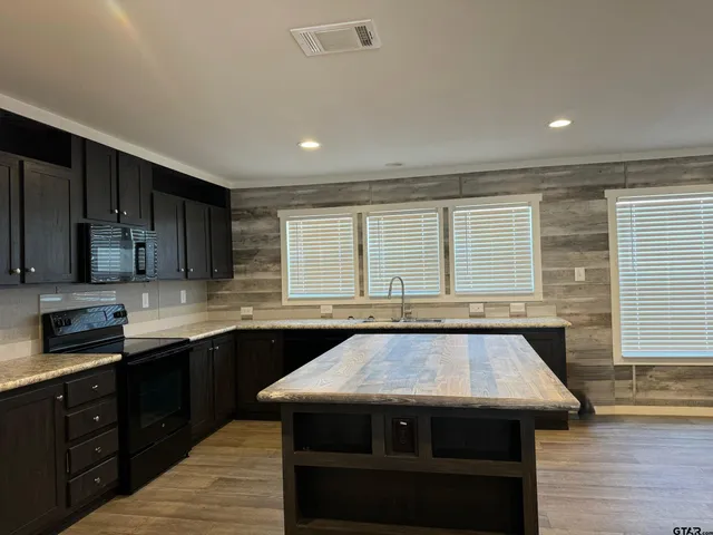 a kitchen with a stove sink and cabinets