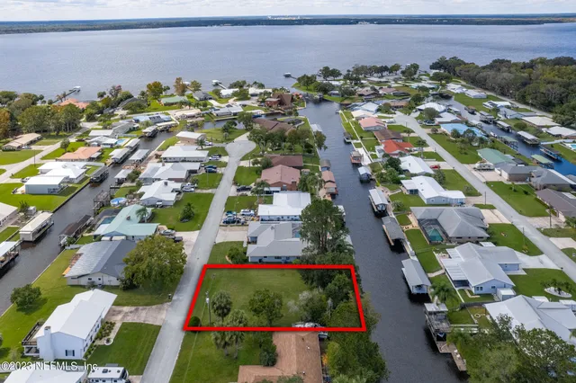 an aerial view of residential houses with outdoor space and river