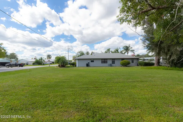 a view of a big yard with a house in the background