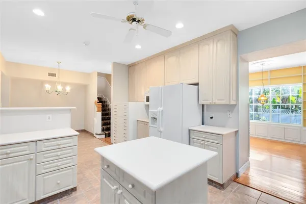 a large white kitchen with a large window appliances and cabinets