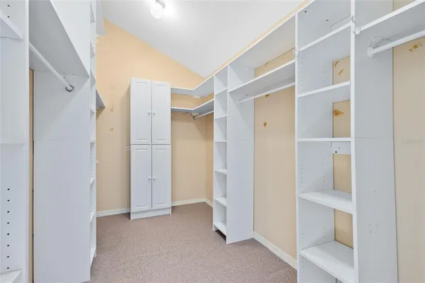 a bedroom with a bed and a lamp on dresser