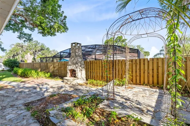a sign that is on a wooden wall under a tree