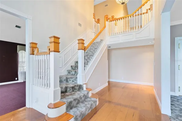 a view of entryway and hall with wooden floor