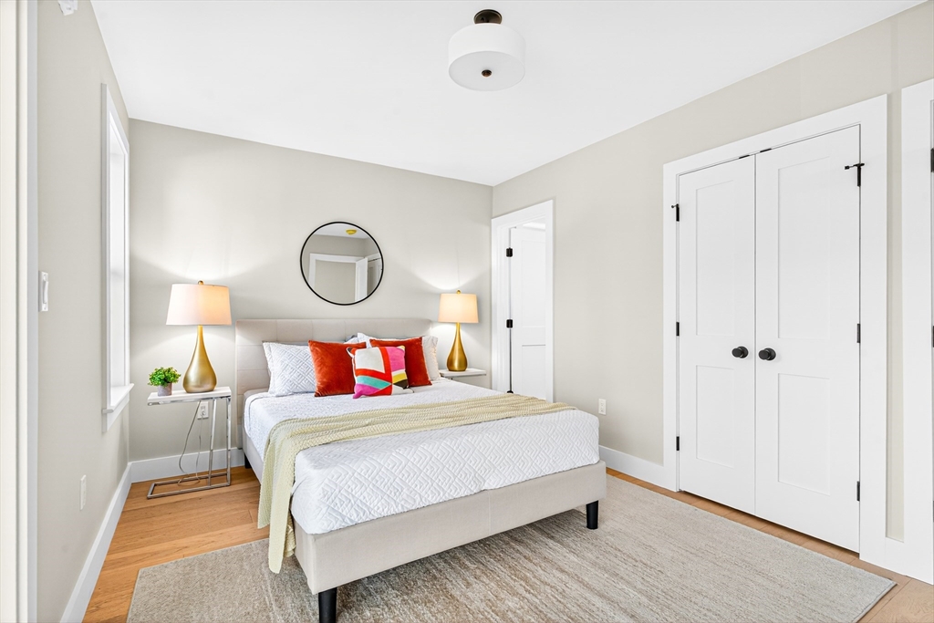 584 Cambridge Street, Unit 1 Boston, MA 02134 - Photo 5 of 17 a bedroom with a bed and a lamp with the wooden floor