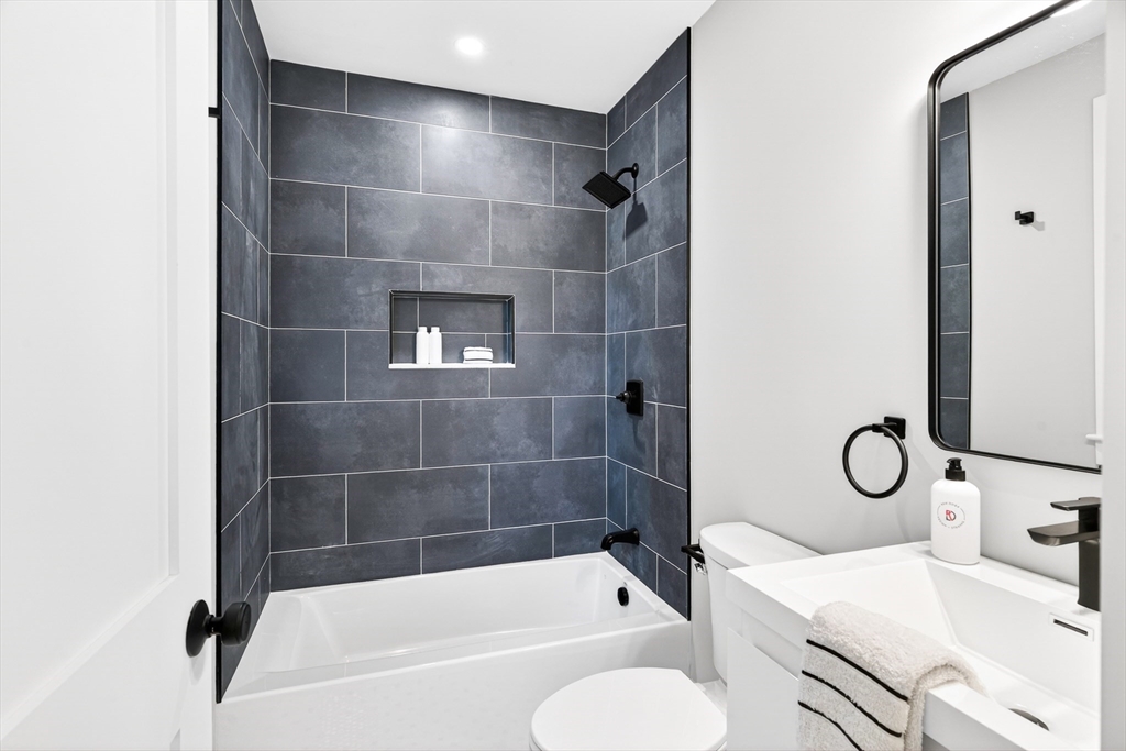 584 Cambridge Street, Unit 1 Boston, MA 02134 - Photo 6 of 17 a bathroom with a bath tub a toilet and a sink