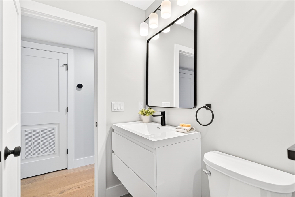 584 Cambridge Street, Unit 1 Boston, MA 02134 - Photo 10 of 17 a bathroom with a toilet sink and mirror