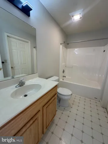 a bathroom with a granite countertop sink a toilet a mirror and shower