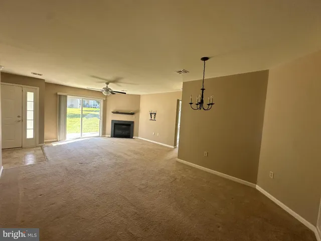 a furnished livingroom with a fireplace and window
