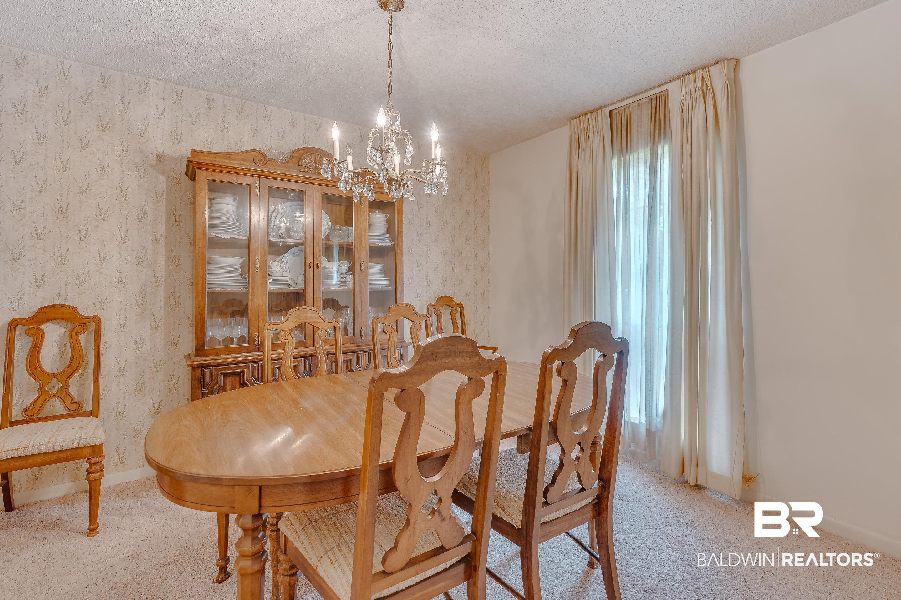 5151 McCrary Road Semmes, AL 36575 - Photo 48 of 62 Dining room featuring a chandelier, wallpapered walls, a textured ceiling, carpet, and baseboards