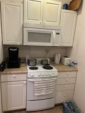 a stove top oven sitting inside of a kitchen