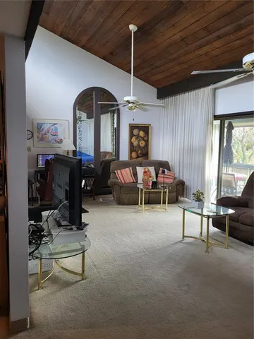 a living room with furniture gym equipment and large windows