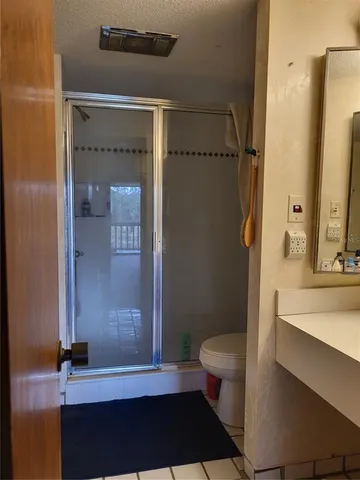 a bathroom with a sink a toilet a shower and a mirror