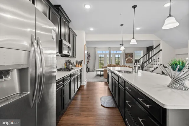 a kitchen with stainless steel appliances granite countertop a sink a stove and a refrigerator