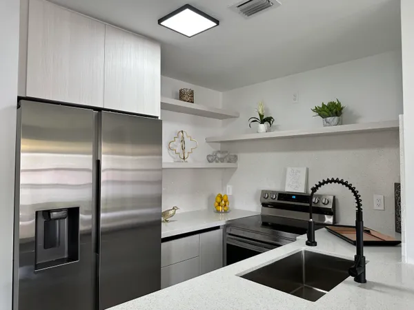 a kitchen with stainless steel appliances a sink and a refrigerator