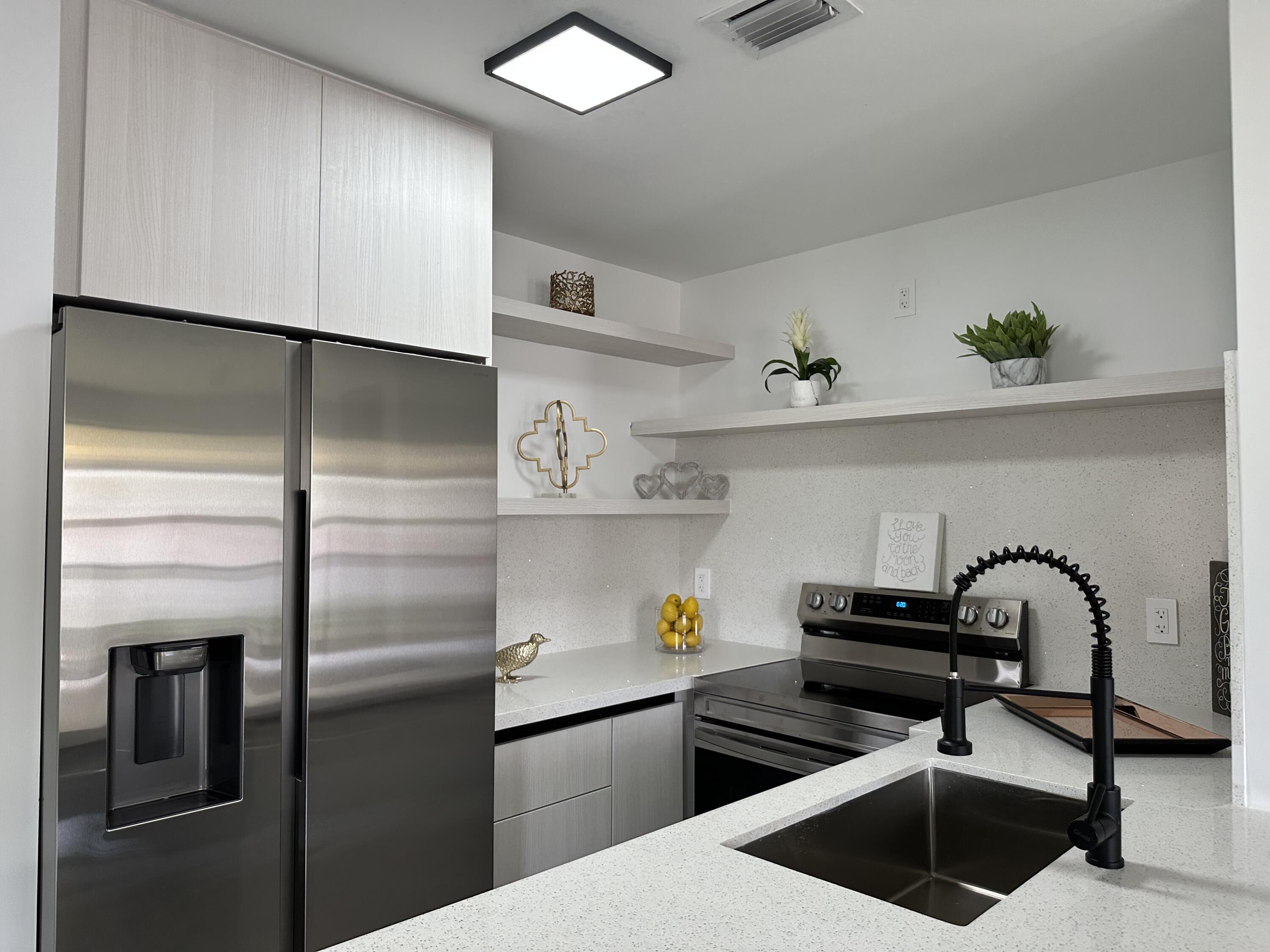 10033 Winding Lake Road, Unit 204 Sunrise, FL 33351 - Photo 11 of 37 a kitchen with stainless steel appliances a sink and a refrigerator