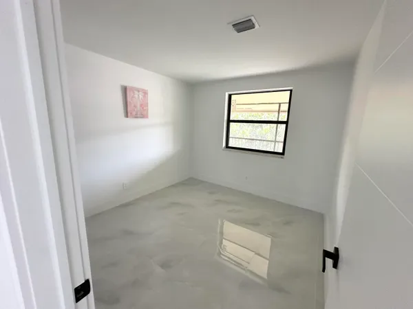 an empty room with closet and mirror