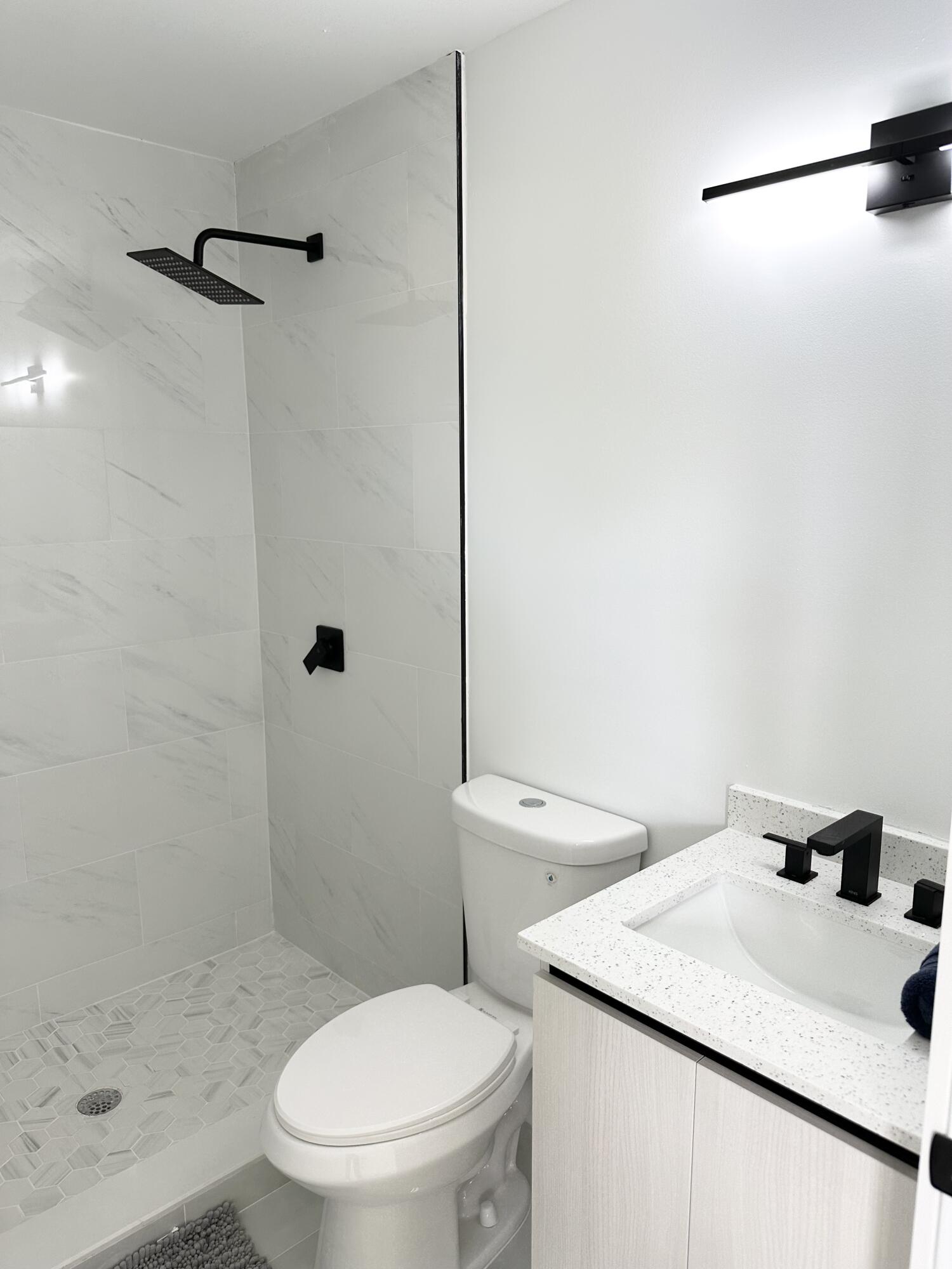 10033 Winding Lake Road, Unit 204 Sunrise, FL 33351 - Photo 4 of 37 a white toilet sitting next to a bathroom sink