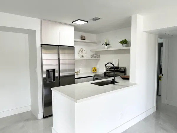 a kitchen with sink a refrigerator and cabinets
