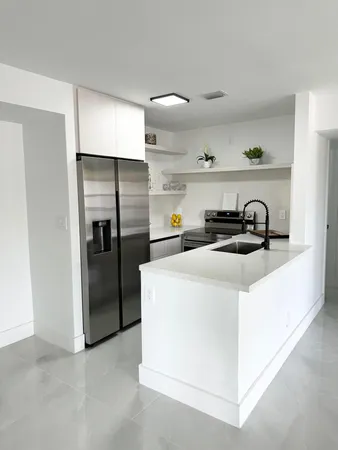 a kitchen with a refrigerator and a stove top oven