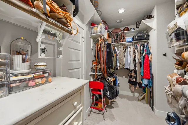 a view of walk in closet with clothes