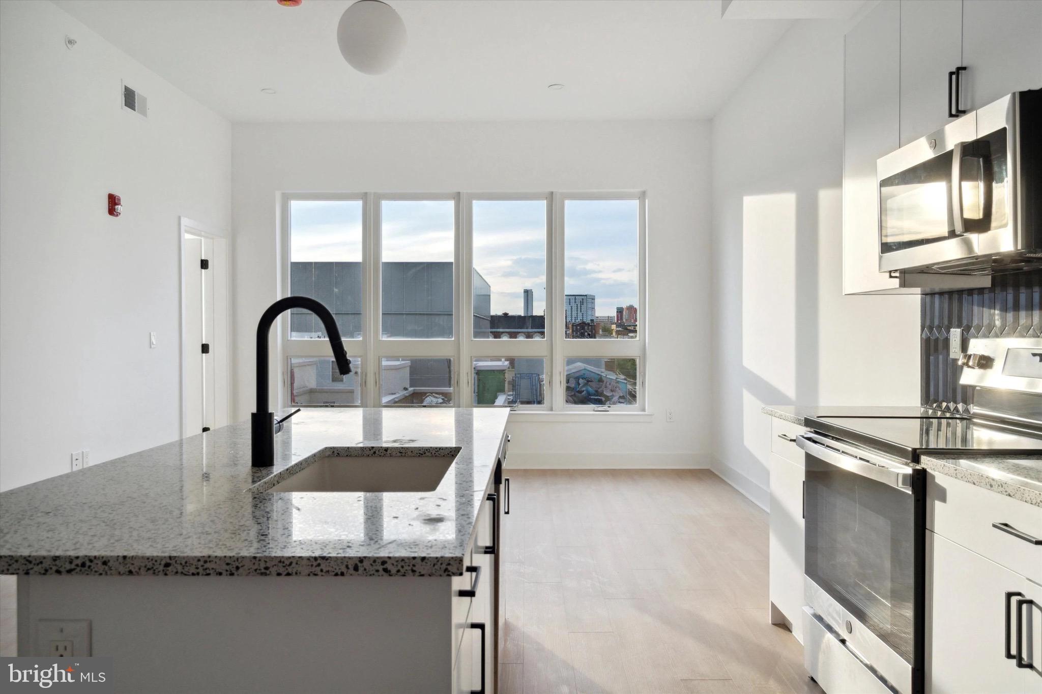 1643 North 2nd Street, Unit 302 Philadelphia, PA 19122 - Photo 4 of 40 a kitchen with granite countertop a stove a sink and a granite counter tops
