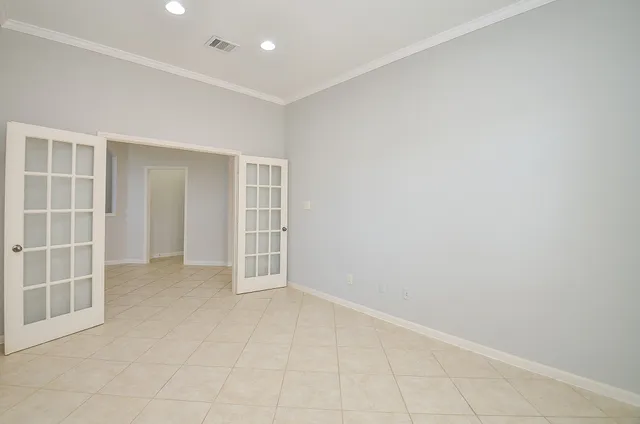 an empty room with chandelier fan and windows