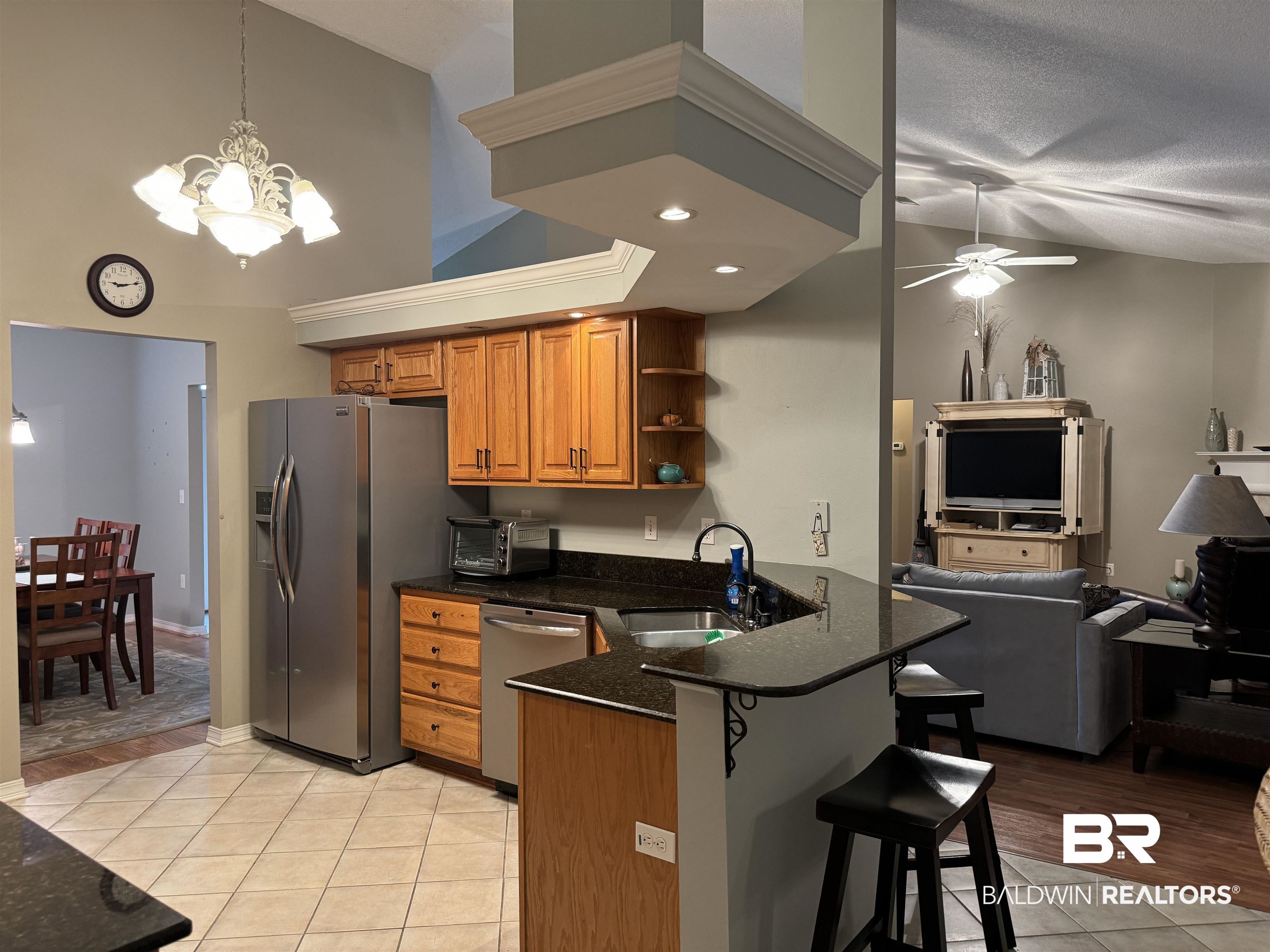 9139 Clubhouse Drive Foley, AL 36535 - Photo 16 of 30 Kitchen with light tile patterned flooring, ceiling fan with notable chandelier, sink, appliances with stainless steel finishes, and kitchen peninsula