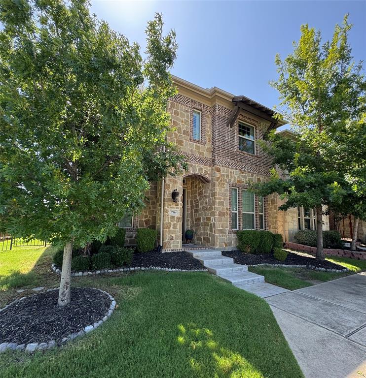 796 Huntingdon Street Coppell, TX 75019 - Photo 2 of 32 a view of a yard in front of a brick house with large windows