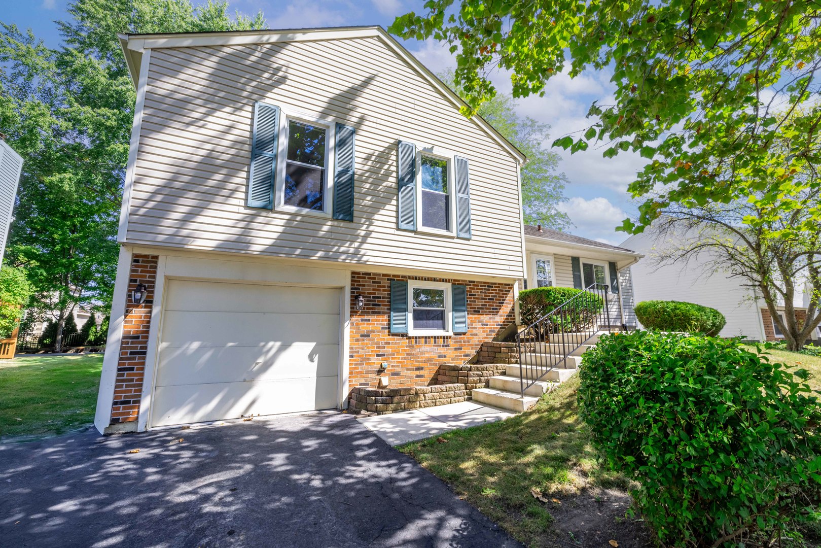 983 Stuart Drive Bartlett, IL 60103 - Photo 2 of 25 a front view of a house with garden