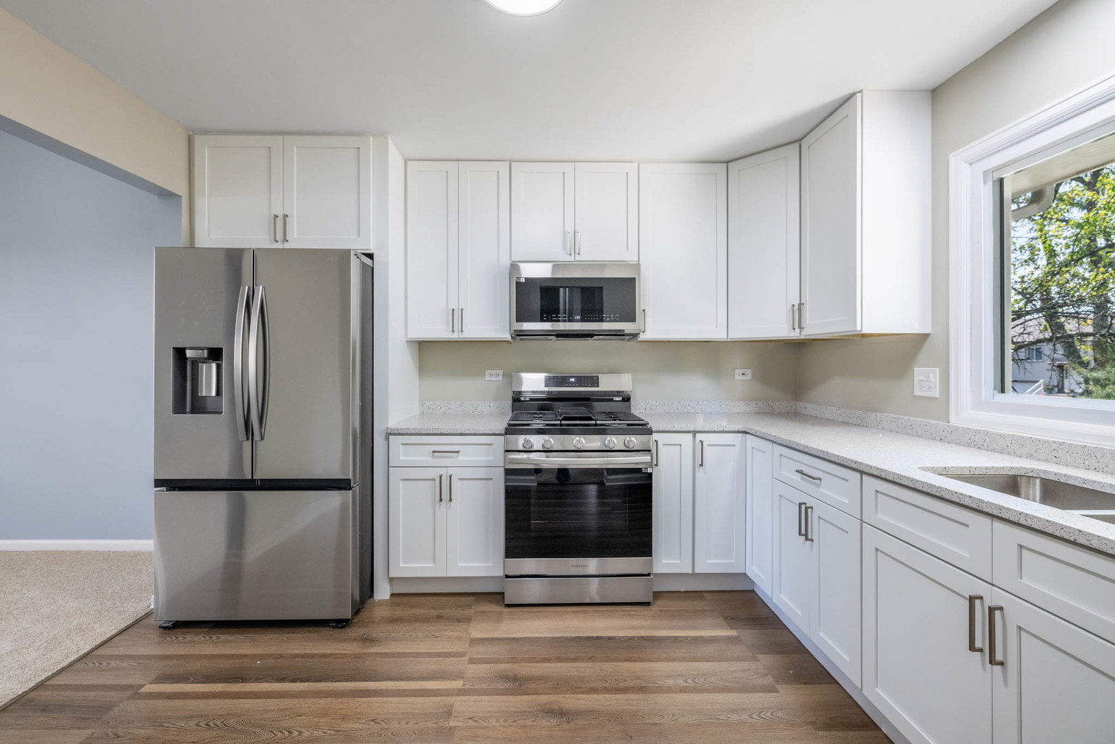 983 Stuart Drive Bartlett, IL 60103 - Photo 8 of 25 a kitchen with granite countertop a refrigerator stove and microwave