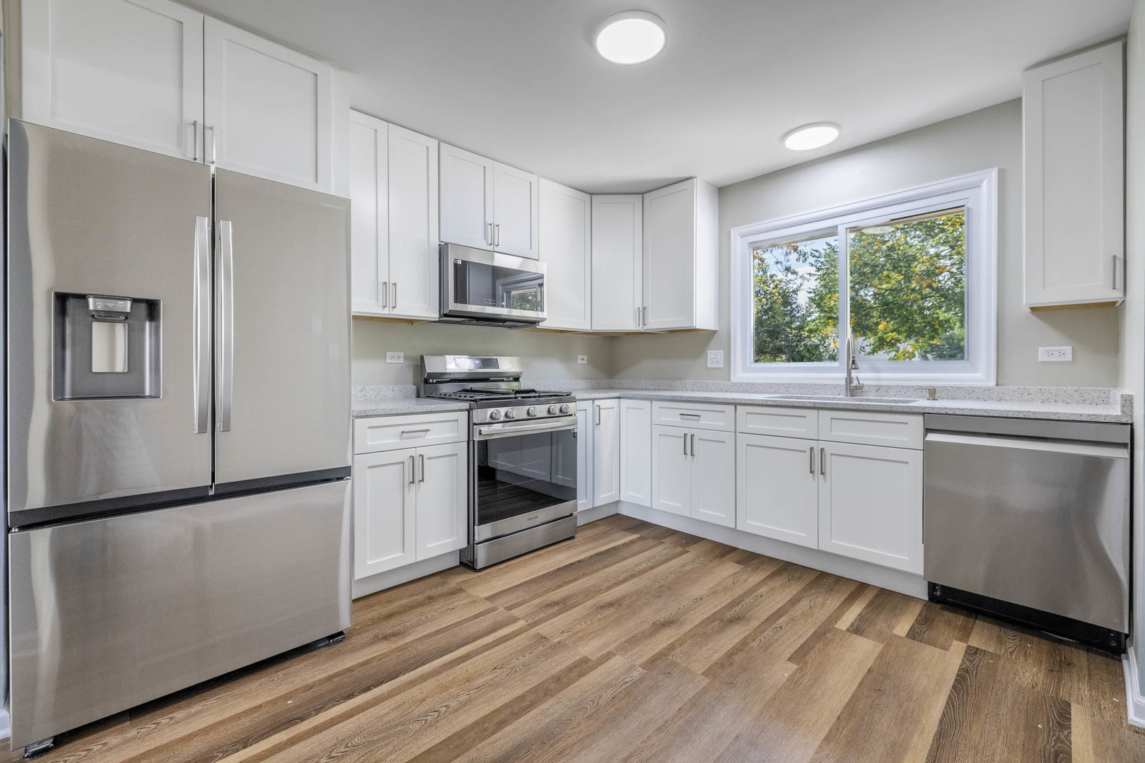 983 Stuart Drive Bartlett, IL 60103 - Photo 10 of 25 a kitchen with granite countertop white cabinets and white stainless steel appliances